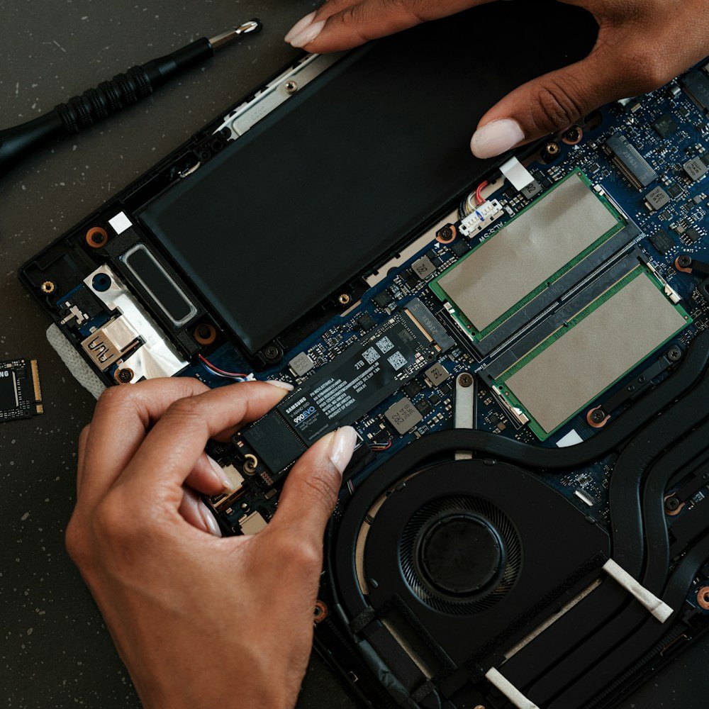 Technician checking a laptop battery and motherboard